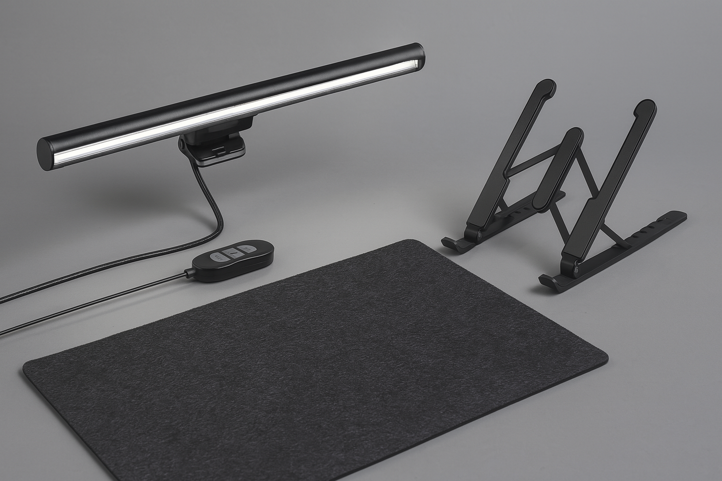 Black desk setup with a mat, lamp, and adjustable stand on a gray background