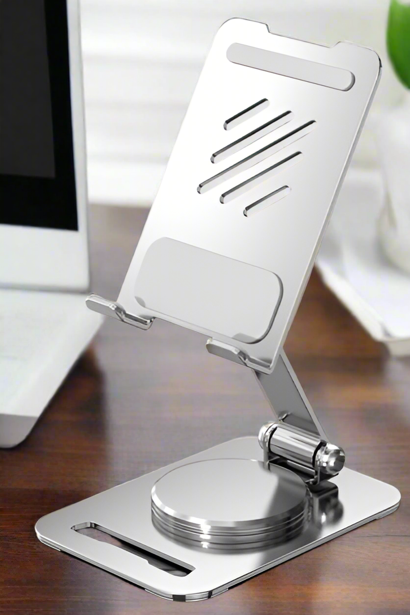 Metal phone stand on a desk with a blurred background