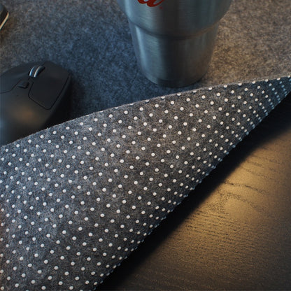Gray mouse pad with polka dot grip on bottom.
